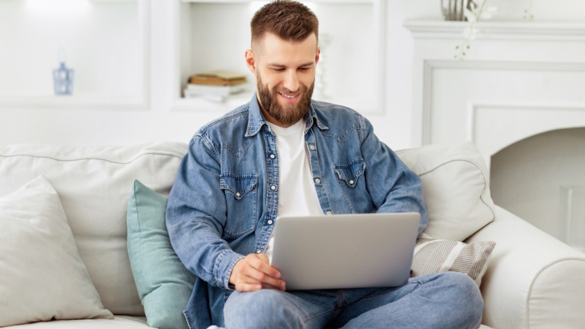 Man Sitting on Couch Using Laptop