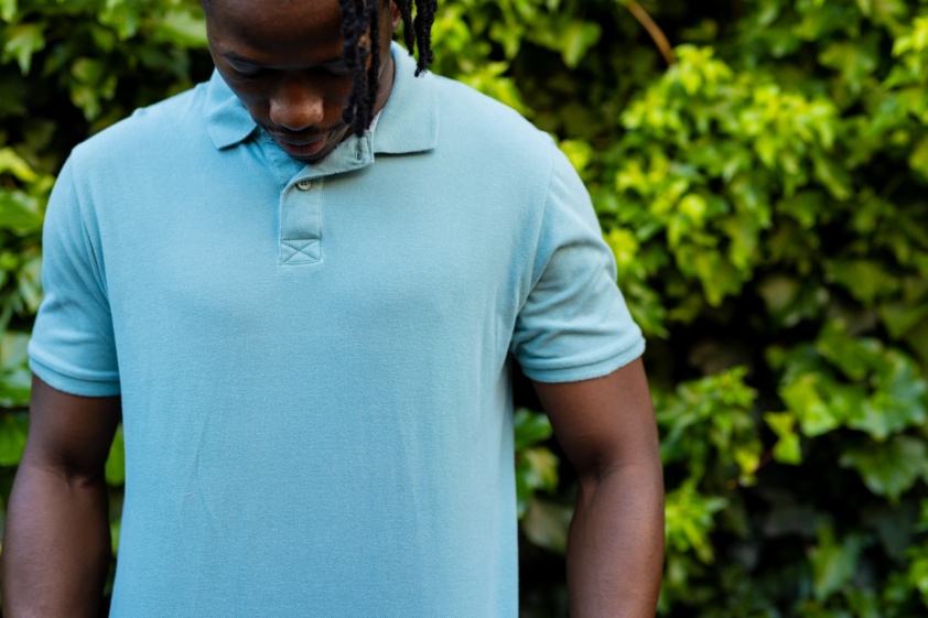 Midsection of african american man wearing pale blue polo shirt in garden